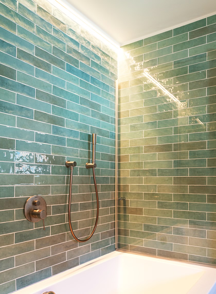 Grote inloopdouche met groene metrotegels in rijwoning centrum Gent