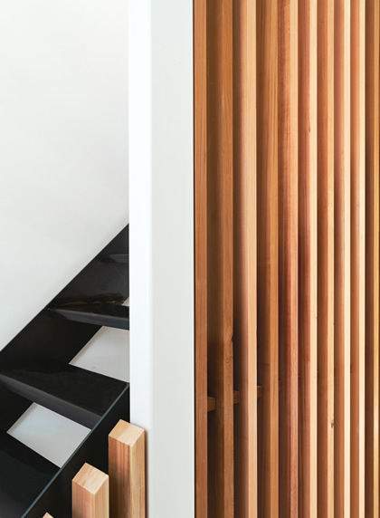 Houten raster voor zwarte vernieuwde trap in rijwoning centrum Gent